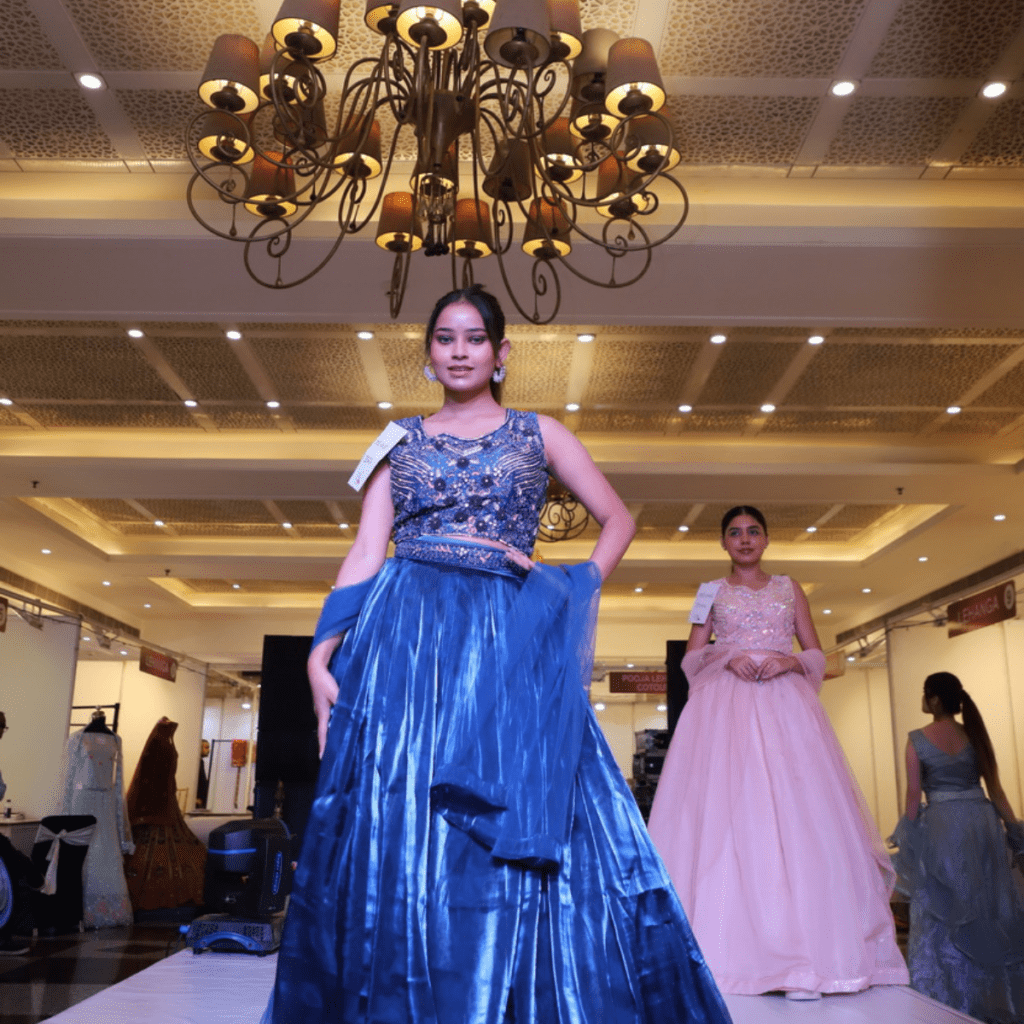 A girl wearing a blue gown performs on stage.