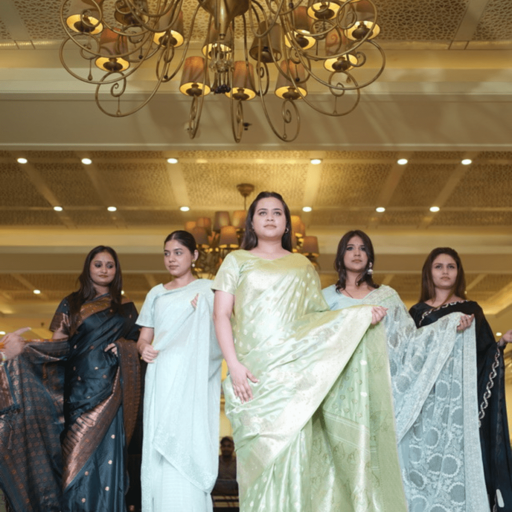 A women displaying saree design on stage.